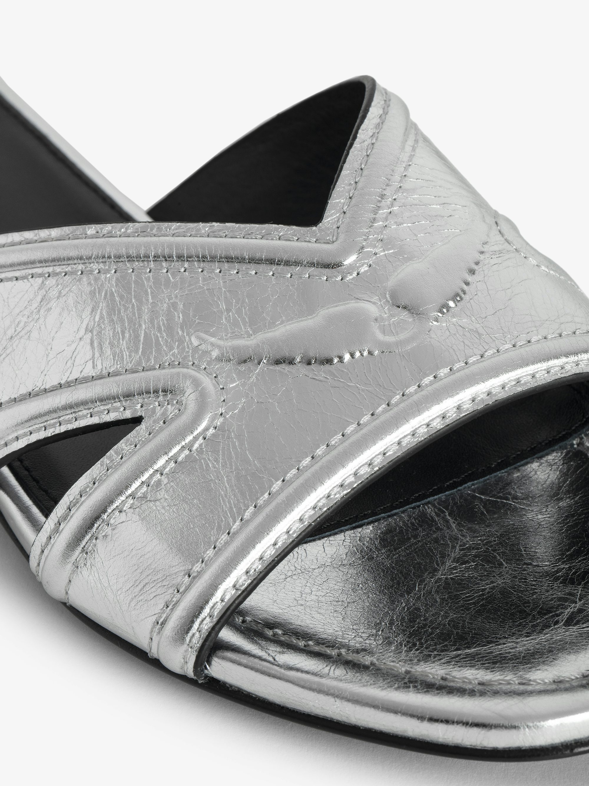 Azora Mules - A harmonious blend of edgy design and luxurious craftsmanship. These mules feature a metallic crinkled leather exterior, exuding a bold yet sophisticated allure. The embossed signature wings add a distinctive touch, embodying the brand's rebellious spirit. Designed with a square toe and crossover strap at the toe, they offer both style and comfort.